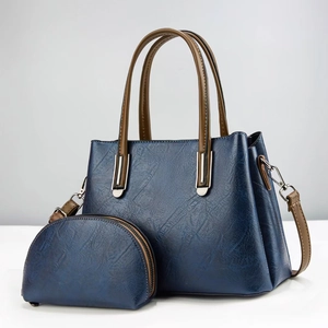 Détail du sac fourre-tout bleu marine avec bandoulières marron et pochette assortie