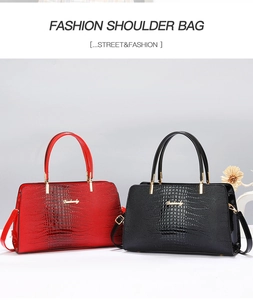 Detailed view of red and black faux crocodile skin handbags with gold logo and hardware