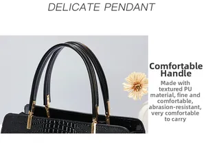 Close-up of black crocodile pattern PU leather handbag with golden metal handle joints
