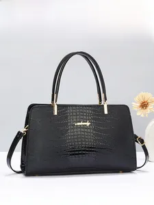 Detailed view of black crocodile pattern leather handbag with elegant gold hardware