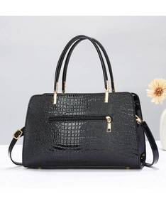 Close-up of black crocodile pattern tote bag with dual handles and metal zipper detail