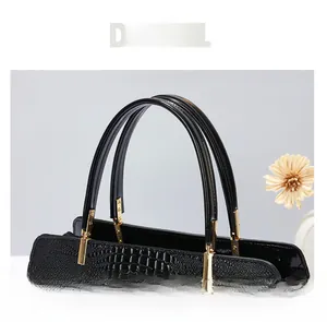 Detail view of the crocodile embossed leather handle with gold-tone metal hardware