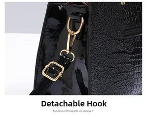 Detail of crocodile embossed leather handbag with gold metal hook and detachable strap