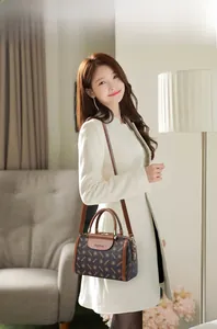 Brown monogram Boston bag styled as a crossbody purse in a cozy home setting decor