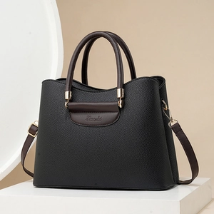 Elegante zwart-bruine handtas van generfd leer met goudkleurige metalen hardware accenten