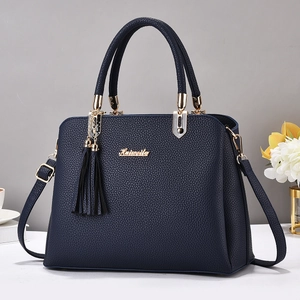 Kaiweilu dark blue litchi leather handbag with gold hardware and tassel detail