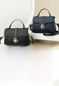 Close-up of litchi grain leather handbags in black and navy with contrast brown handles