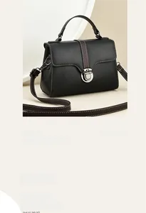 Close-up of a mini black lychee leather handbag featuring a silver metal push-lock buckle