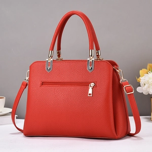 Red lychee textured leather tote bag with dual handles and gold zipper on gray background