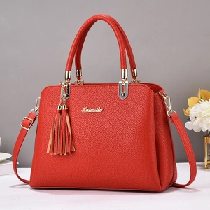 Red lychee grain leather handbag with gold metal logo and decorative tassel ornament