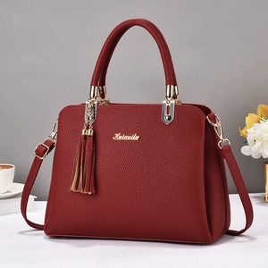Elegant red leather handbag with tassel charm and gold hardware for women