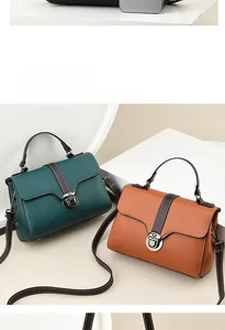 Detail of dark green and caramel leather bags with lychee texture and silver locks