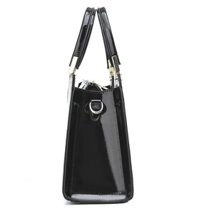 Side view of black patent leather handbag featuring glossy finish and metal D-ring hardware