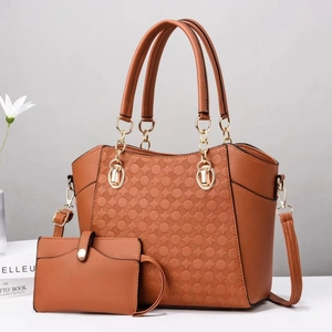 Dettaglio della borsa tote in pelle marrone con rilievi circolari e catena dorata