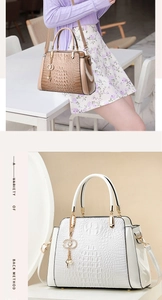 Detail view of crocodile pattern handbag with pearl charm and gold hardware accents