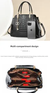 Detail of crocodile embossed handbag showing internal compartments and large storage capacity