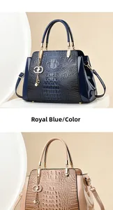 Detail of crocodile-embossed handbags in royal blue and beige with gold hardware