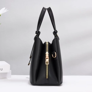 Elegante bolso tote negro con detalles dorados y asas dobles para mujer de moda hoy