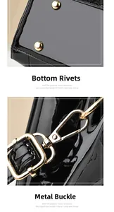 Detail of black faux crocodile handbag with gold bottom studs and metal strap hooks