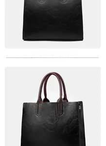 Detail of vintage black textured tote bag featuring contrasting burgundy rolled handles