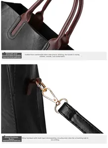 Detail of burgundy leather handles and light gold metal hardware on black tote bag