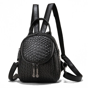 Front view of black woven texture mini backpack with adjustable leather straps on white background