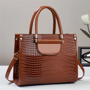 Gros plan sur la texture crocodile marron d'un sac à main en cuir verni brillant