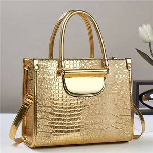 Détail macro du motif crocodile doré sur le sac à main chic avec fermoir en métal brillant