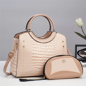 Detail of crocodile embossed leather handbag set with metal floral logo and rivets