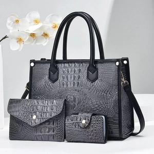 Detailed view of 3-piece black crocodile pattern handbag set with golden hardware