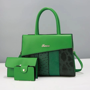 Detailed view of green faux leather handbag set with exotic embossed textures and gold logo