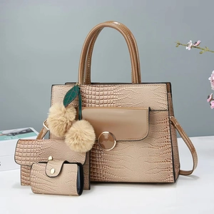 Detailed view of champagne gold 3-in-1 tote set with faux crocodile texture and charms