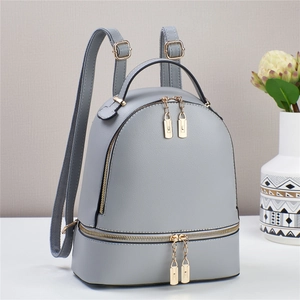 Minimalistischer grauer Damenrucksack aus Kunstleder mit eleganten goldenen Metallteilen