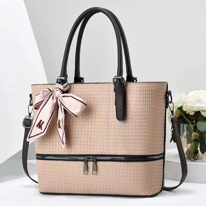 Detail of pink woven leather tote bag with elegant silk scarf and dark brown handles