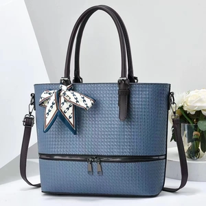 Light blue woven tote bag with brown handles and elegant H-print silk scarf accessory