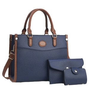 Three-piece navy blue tote bag set with brown handles and gold hardware on white background