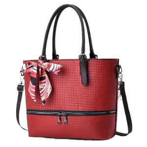 Red woven leather tote bag with dark brown handles and colorful decorative scarf