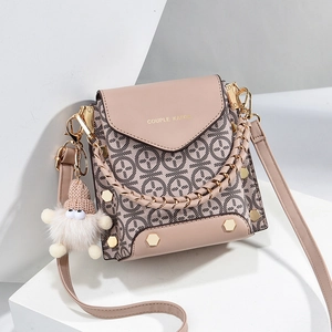 Chic pink patchwork crossbody mini bag with gold hardware and plush charm on white stands