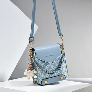 Light blue crossbody phone bag with monogram pattern and cute plush charm on white blocks