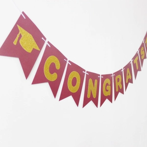 Burgundy and gold graduation banner with glittery Congrats text and doctoral cap
