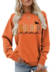Close-up of ribbed cuffs and GOLDEN mama print on this orange crewneck sweatshirt