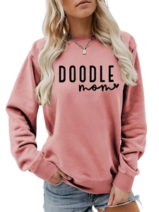 Detail of pink crewneck sweatshirt featuring black DOODLE mom lettering and ribbed cuffs