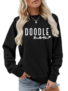 Close-up of white DOODLE mom lettering on a black cotton crewneck sweatshirt fabric