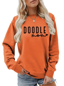 Detail of DOODLE MOM logo and heart print on bright orange crewneck sweatshirt