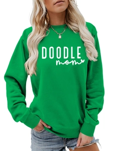 Close-up of DOODLE MOM text print on green crewneck sweatshirt cotton fabric