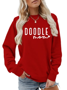 Detail of red crewneck sweatshirt with white DOODLE MOM text and ribbed cuffs