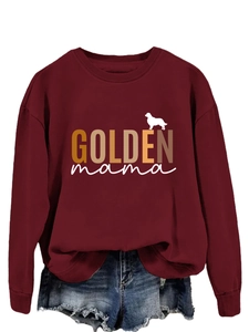Detail of burgundy sweatshirt featuring golden mama text and dog silhouette print