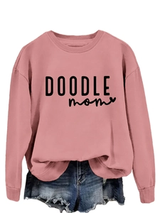 Detailed texture of pink Doodle Mom sweatshirt with black artistic lettering on the chest