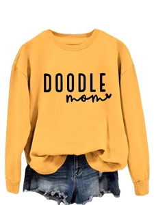 Detail of DOODLE MOM text print on yellow crewneck sweatshirt with ribbed cuffs