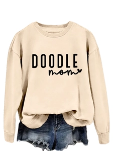 Detail of DOODLE MOM graphic sweatshirt featuring ribbed cuffs and crewneck collar